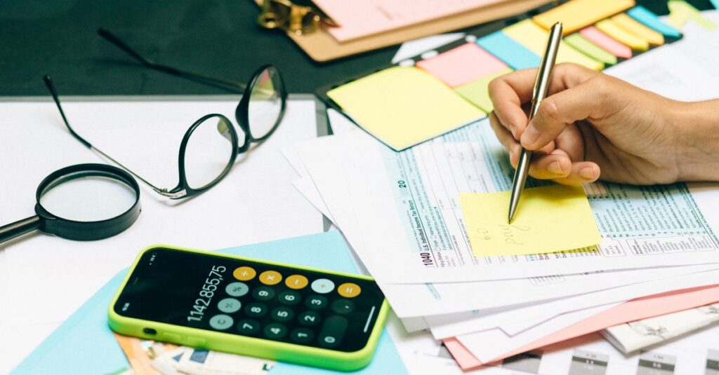 Close-up of an office desk with a calculator, glasses, and documents for financial planning.